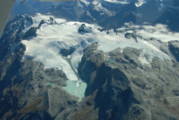 Large chunks of ice are calving off Park Pass Glacier into a pro-glacial lake. At the top of the glacier, above the crevasses, this season's snow is visible as white patches
